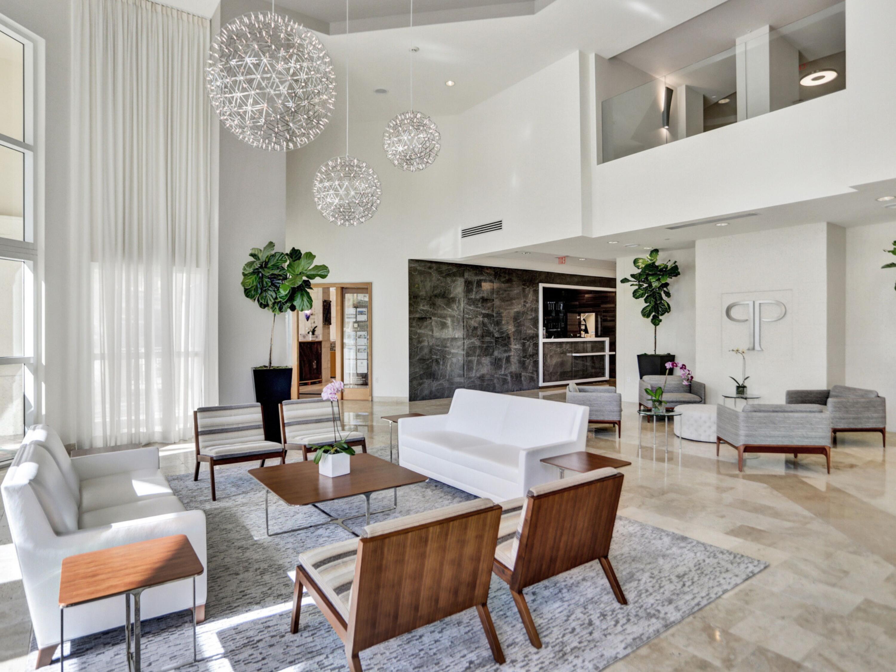 a living room with furniture a chandelier and a large window