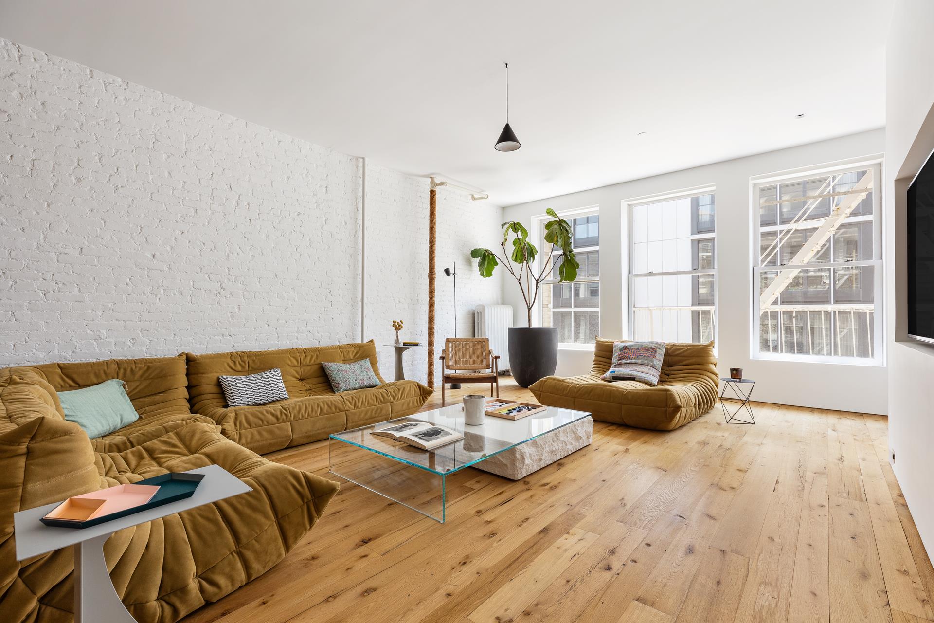 a living room with furniture and floor to ceiling windows