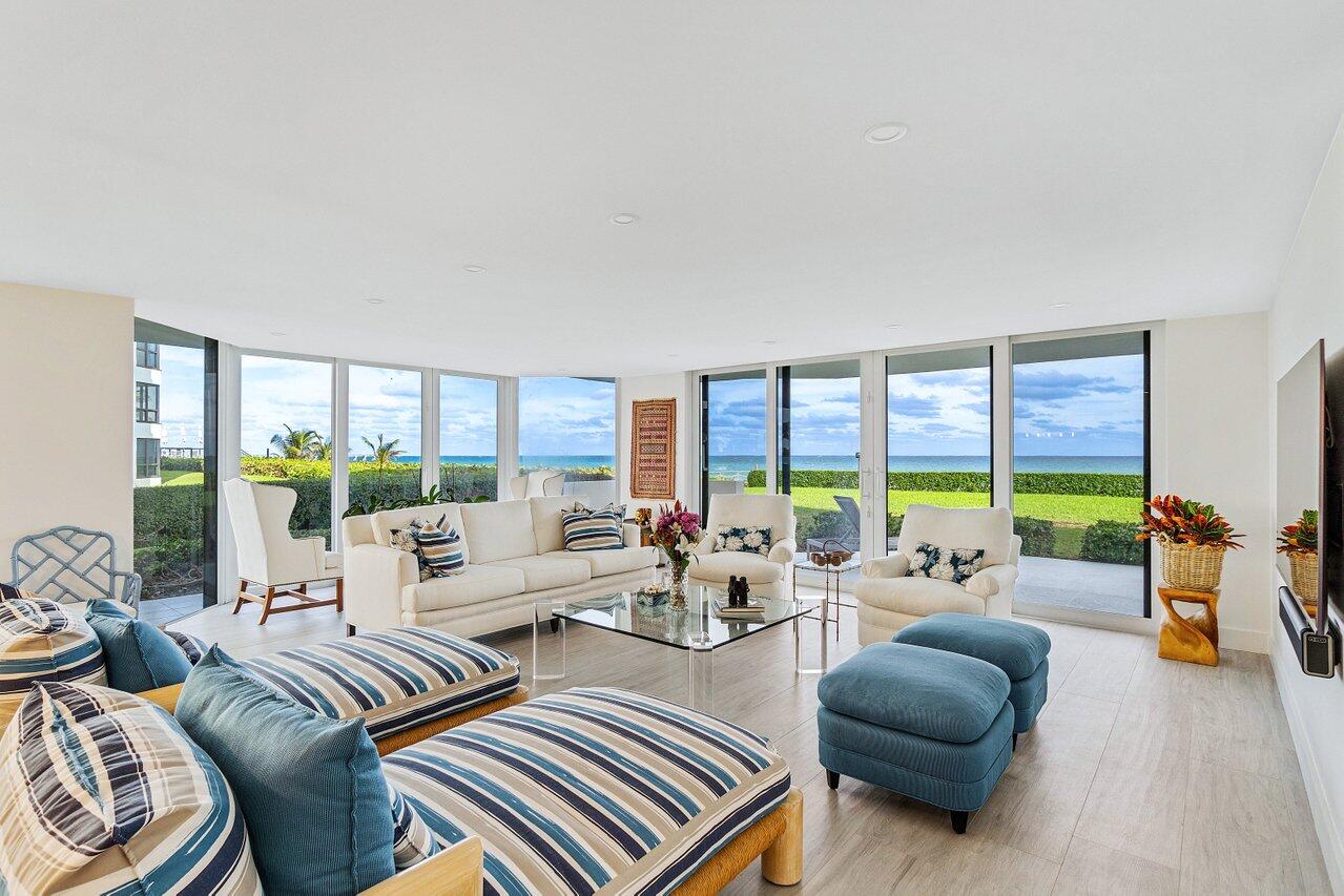 a living room with furniture and floor to ceiling windows