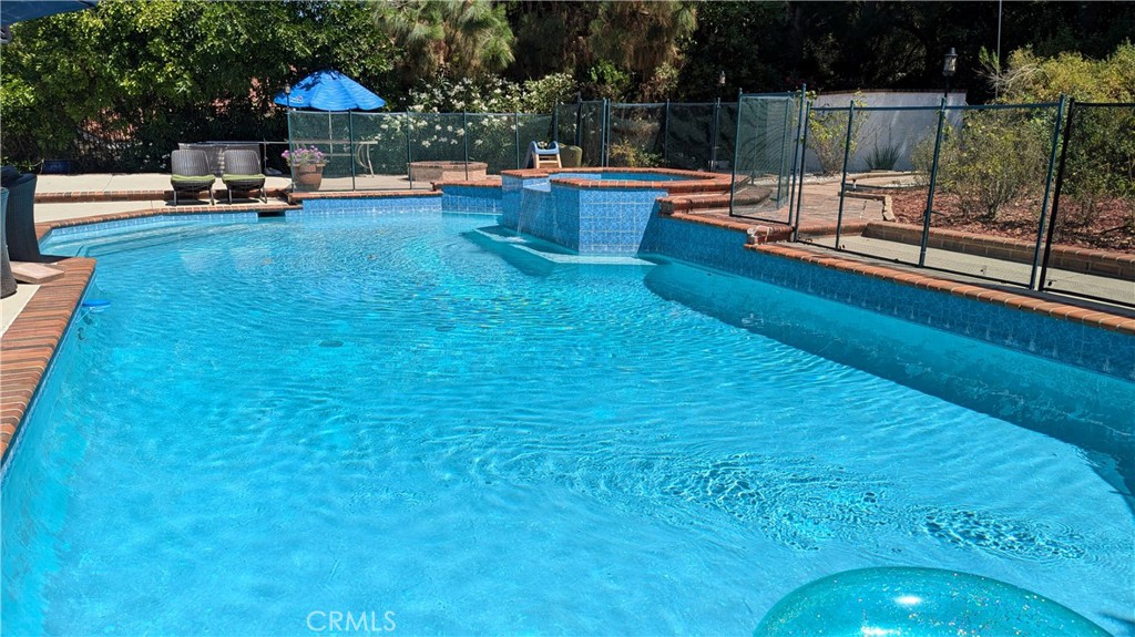 a view of a swimming pool with a patio and a garden