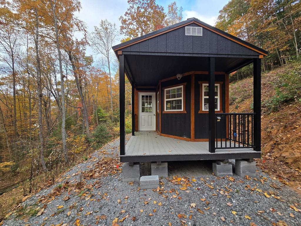 a view of small house with yard and deck