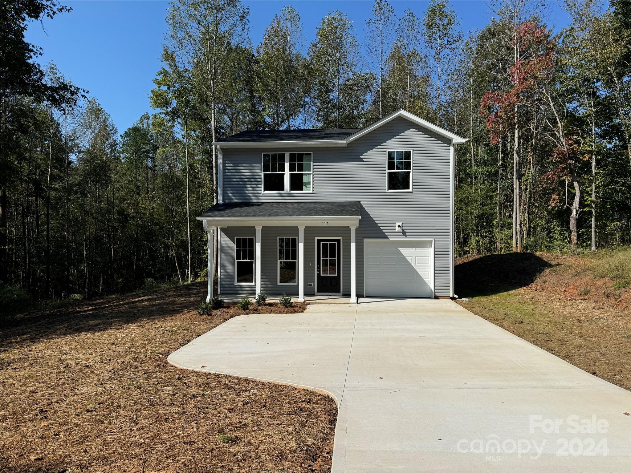 a front view of a house with yard and green space