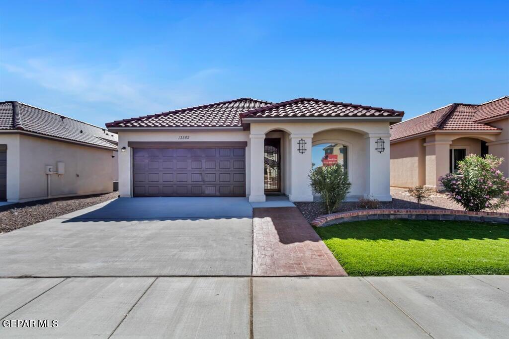 a front view of a house with a yard and garage