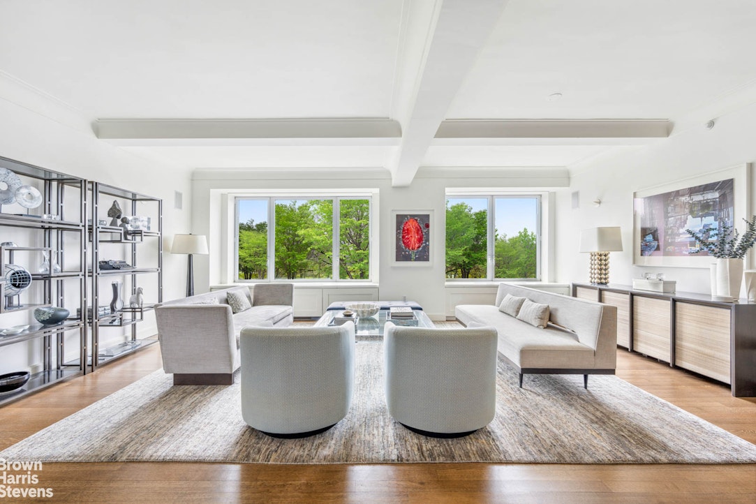 a living room with couches a coffee table and next to a window