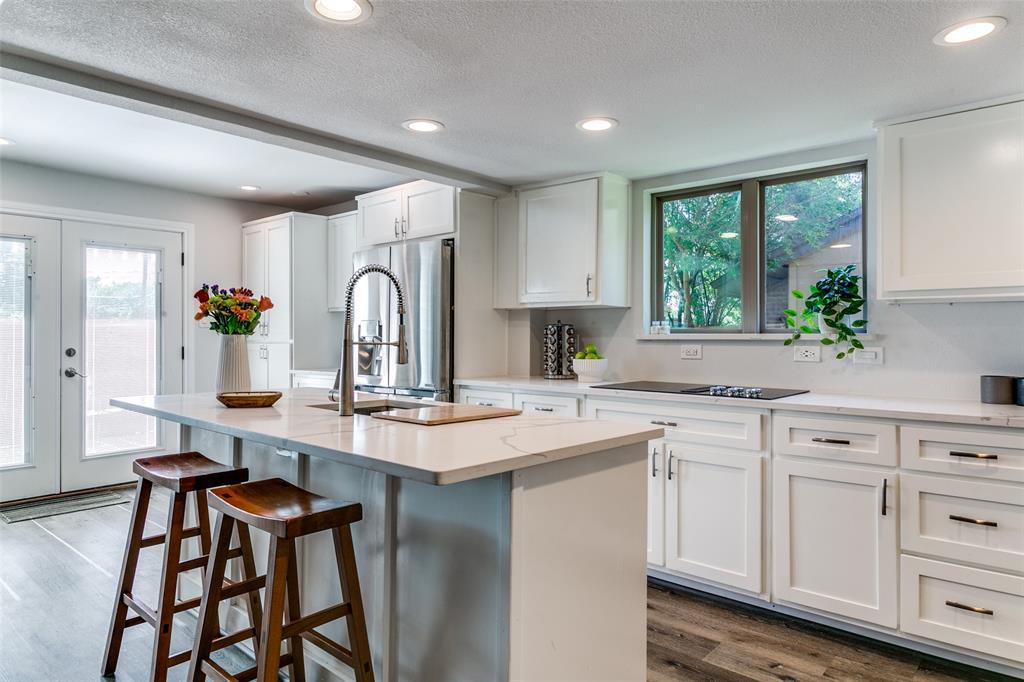 a kitchen with sink a window and chairs