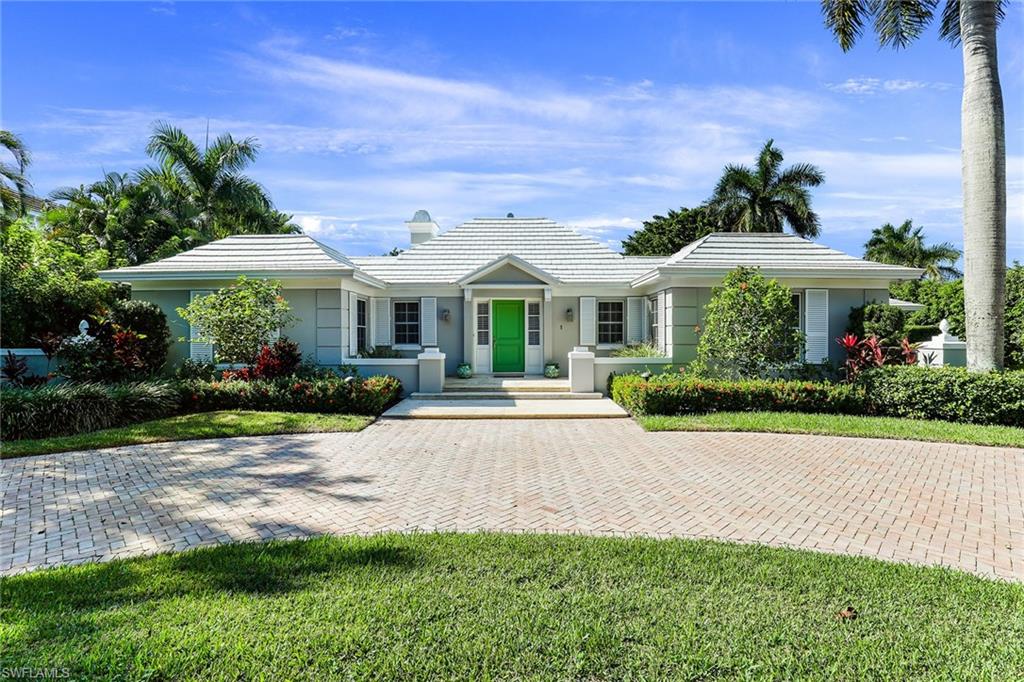 a front view of a house with yard and green space