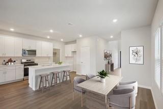 a living room with stainless steel appliances kitchen island granite countertop furniture wooden floor and a kitchen view