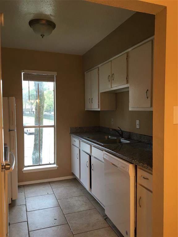 a kitchen with granite countertop a stove a sink and a microwave