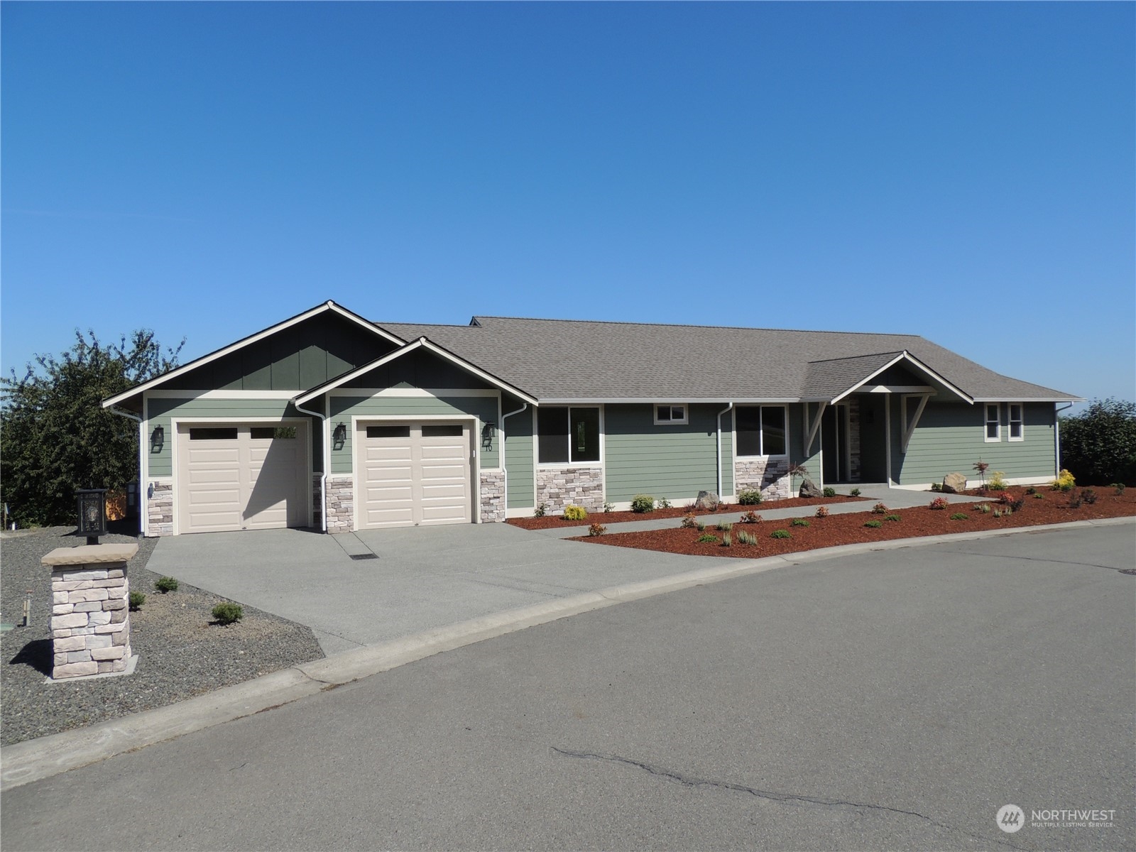 a front view of a house with yard and parking