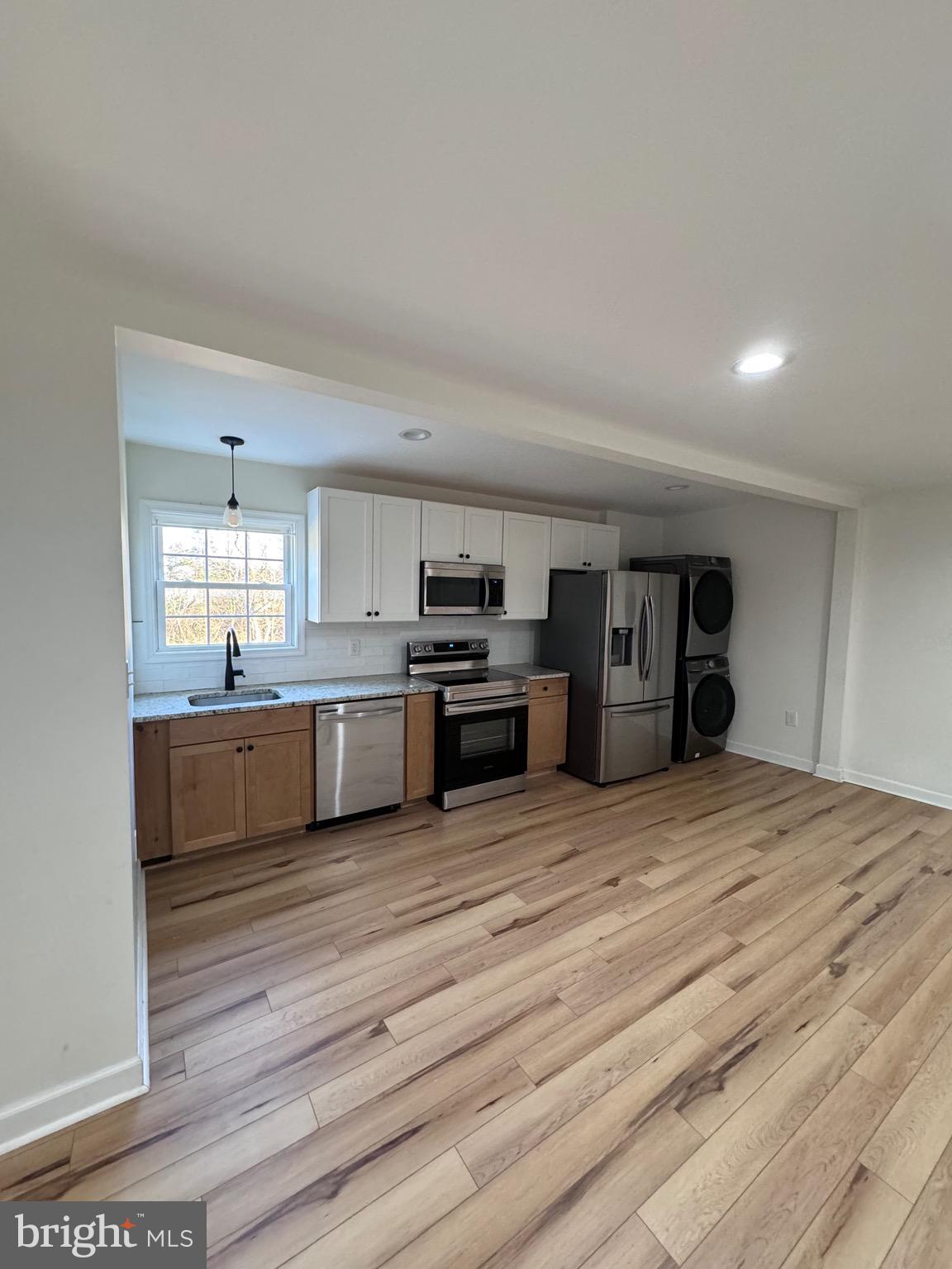 a large kitchen with kitchen island a sink stainless steel appliances and cabinets