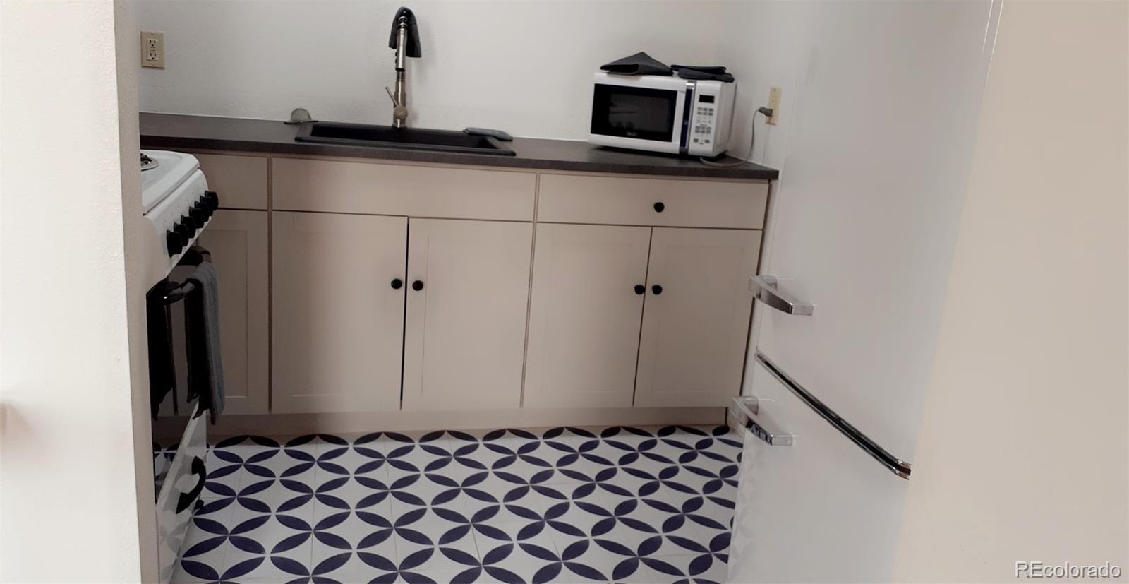 a bathroom with a granite countertop sink and washing machine