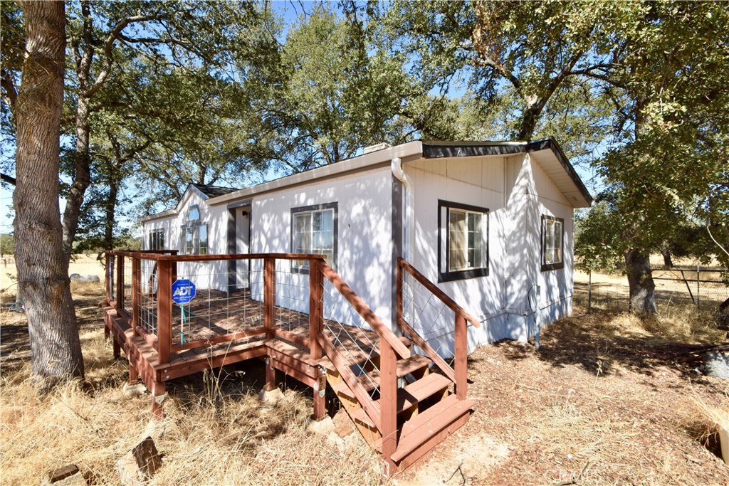 a view of a house with a wooden bench in a yard