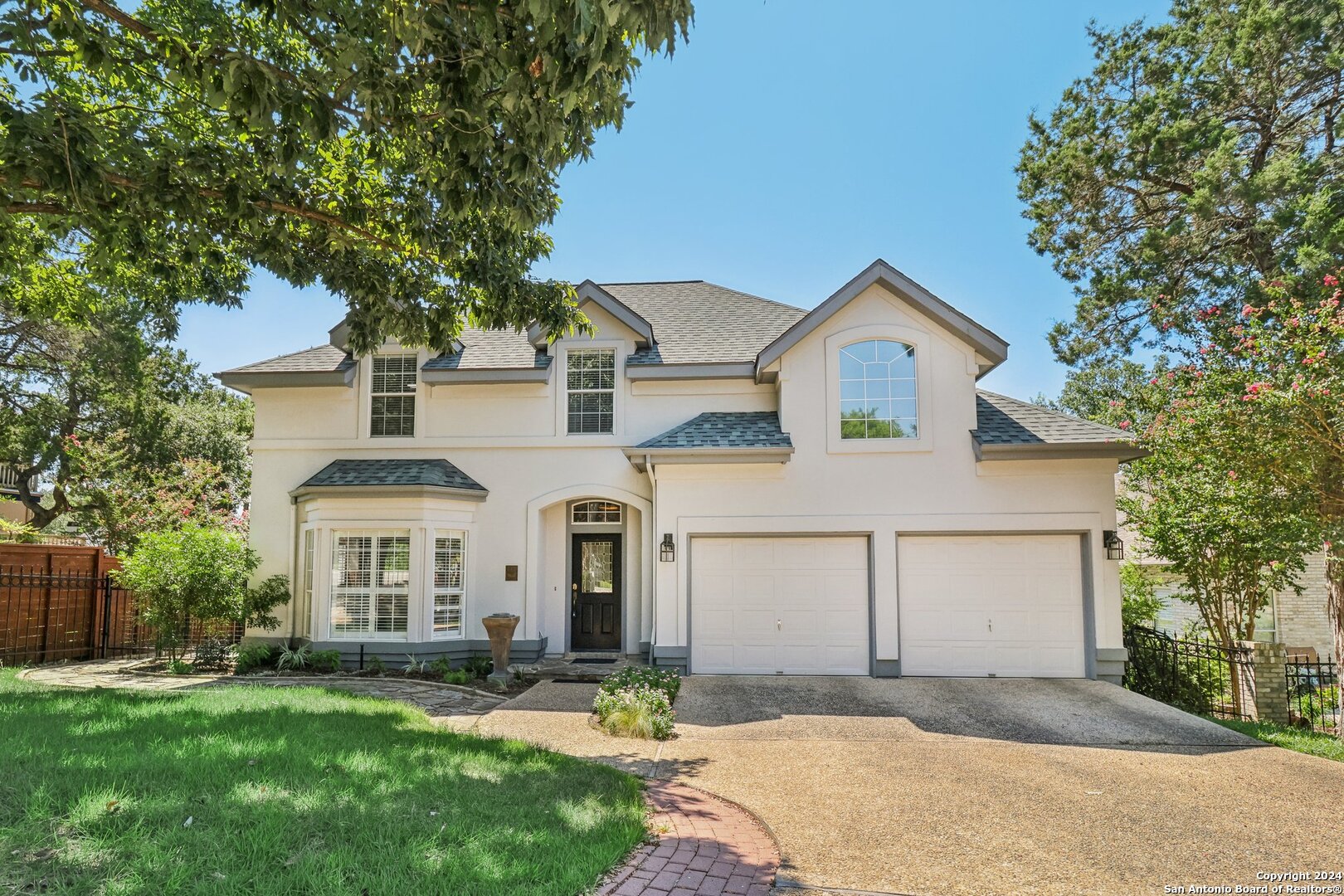 a front view of a house with a garden and yard