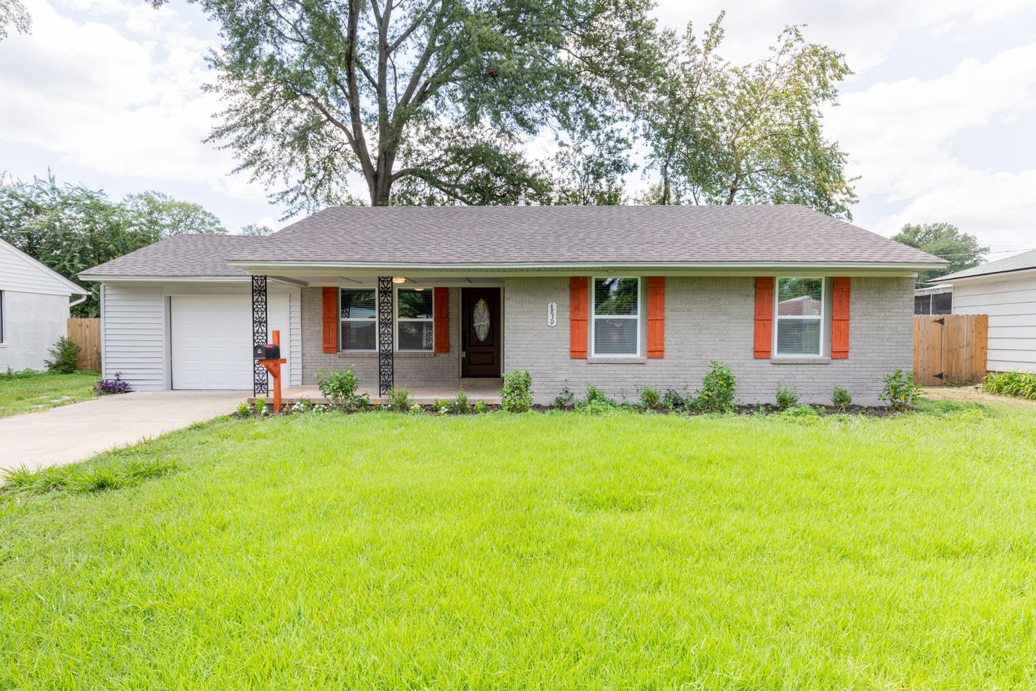 Ranch-style house featuring a garage and a front lawn