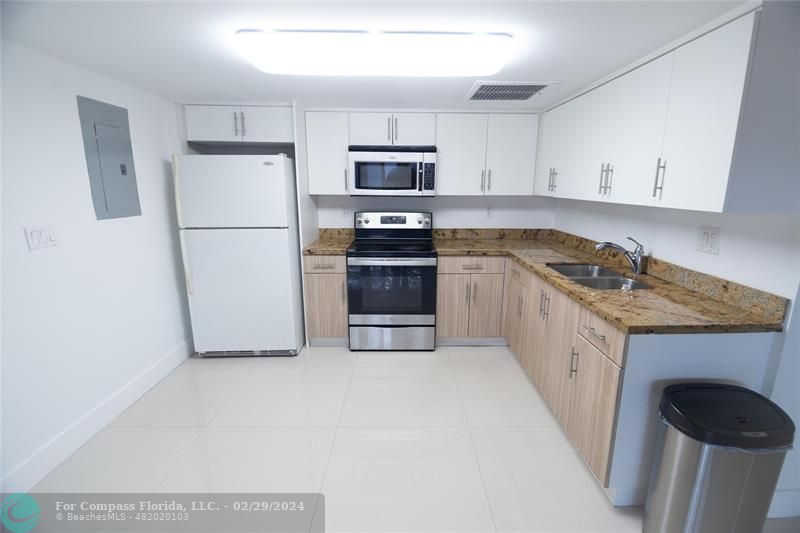 a kitchen with granite countertop a refrigerator and a stove