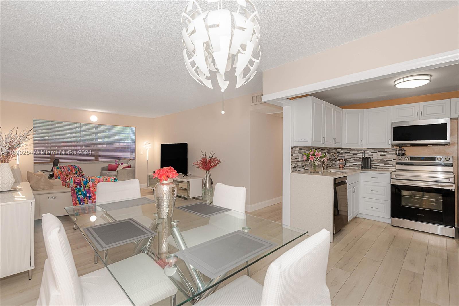 a kitchen with stainless steel appliances kitchen island granite countertop a stove and white cabinets