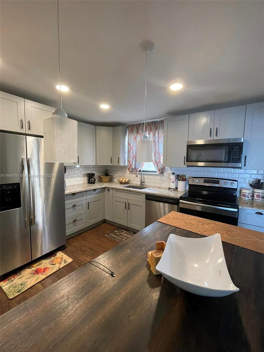 a kitchen with stainless steel appliances granite countertop a sink refrigerator and a microwave