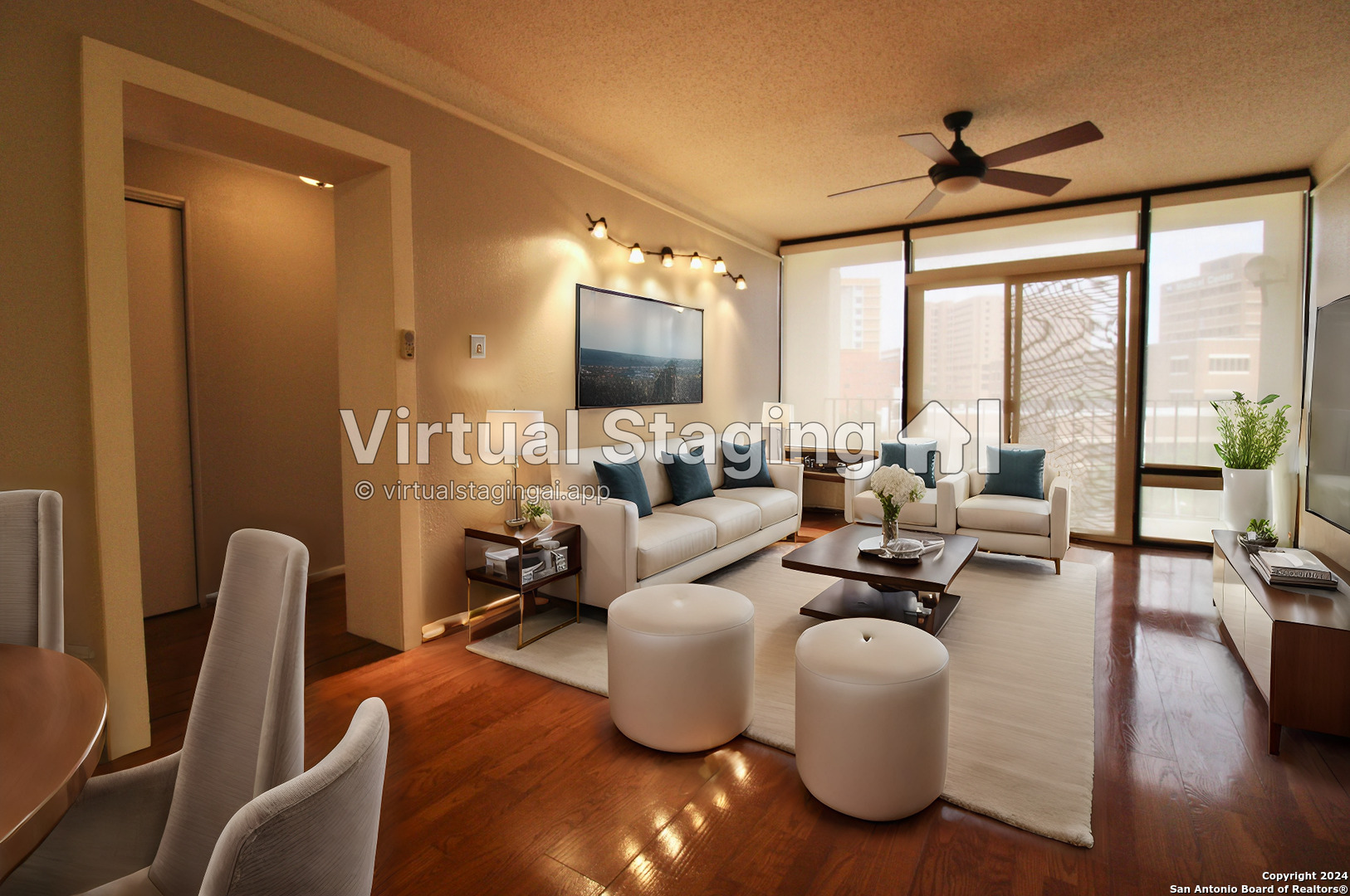 a living room with couches and a flat screen tv with kitchen view