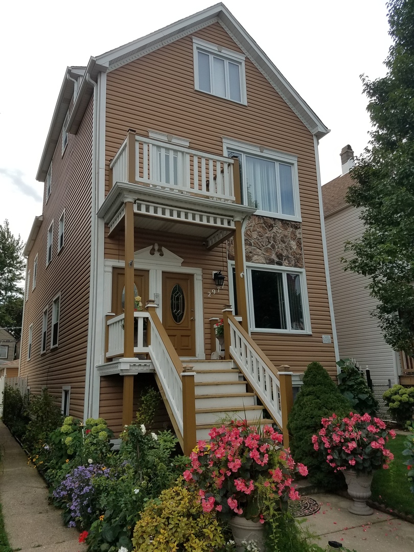 a front view of a house with a lot of flower plants