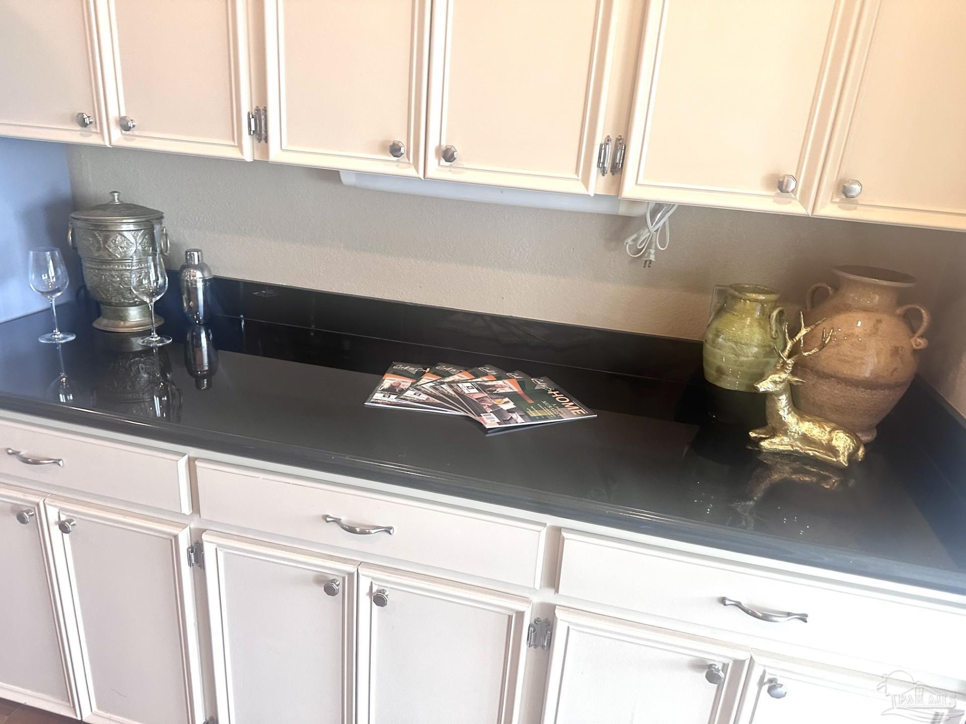 a close view of a sink and a stove with white cabinets