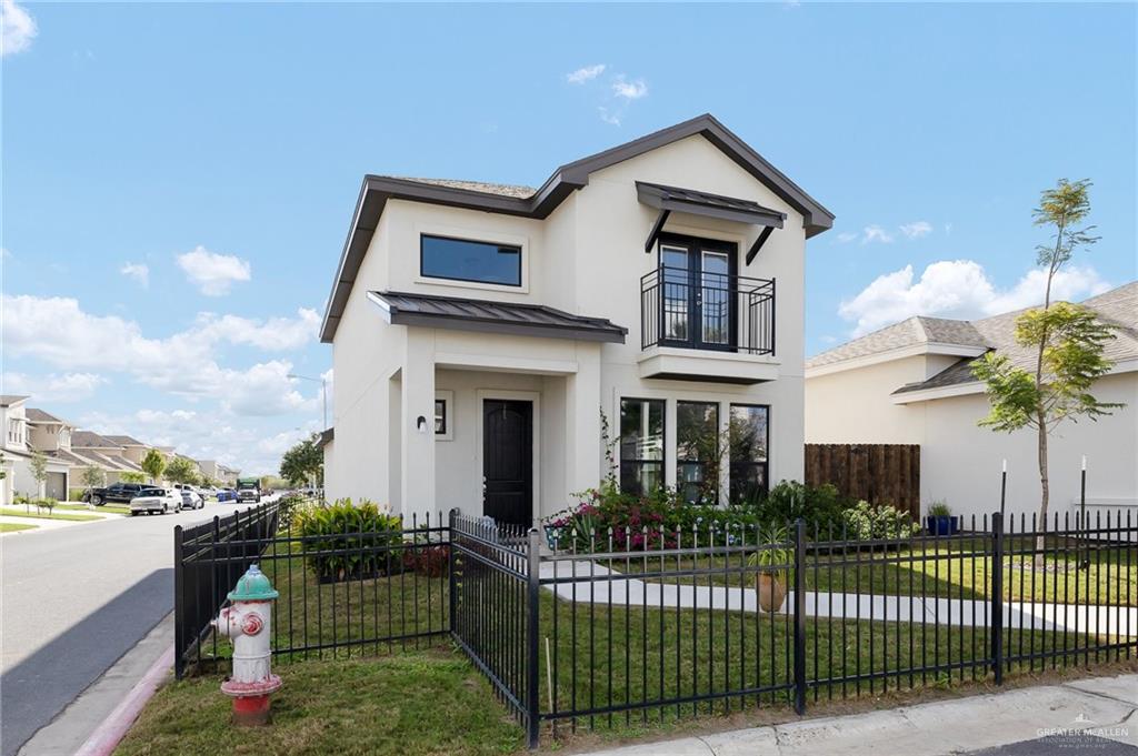 View of front of property with a balcony and a front lawn