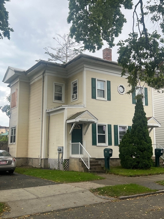 a front view of a house with a garden and plants