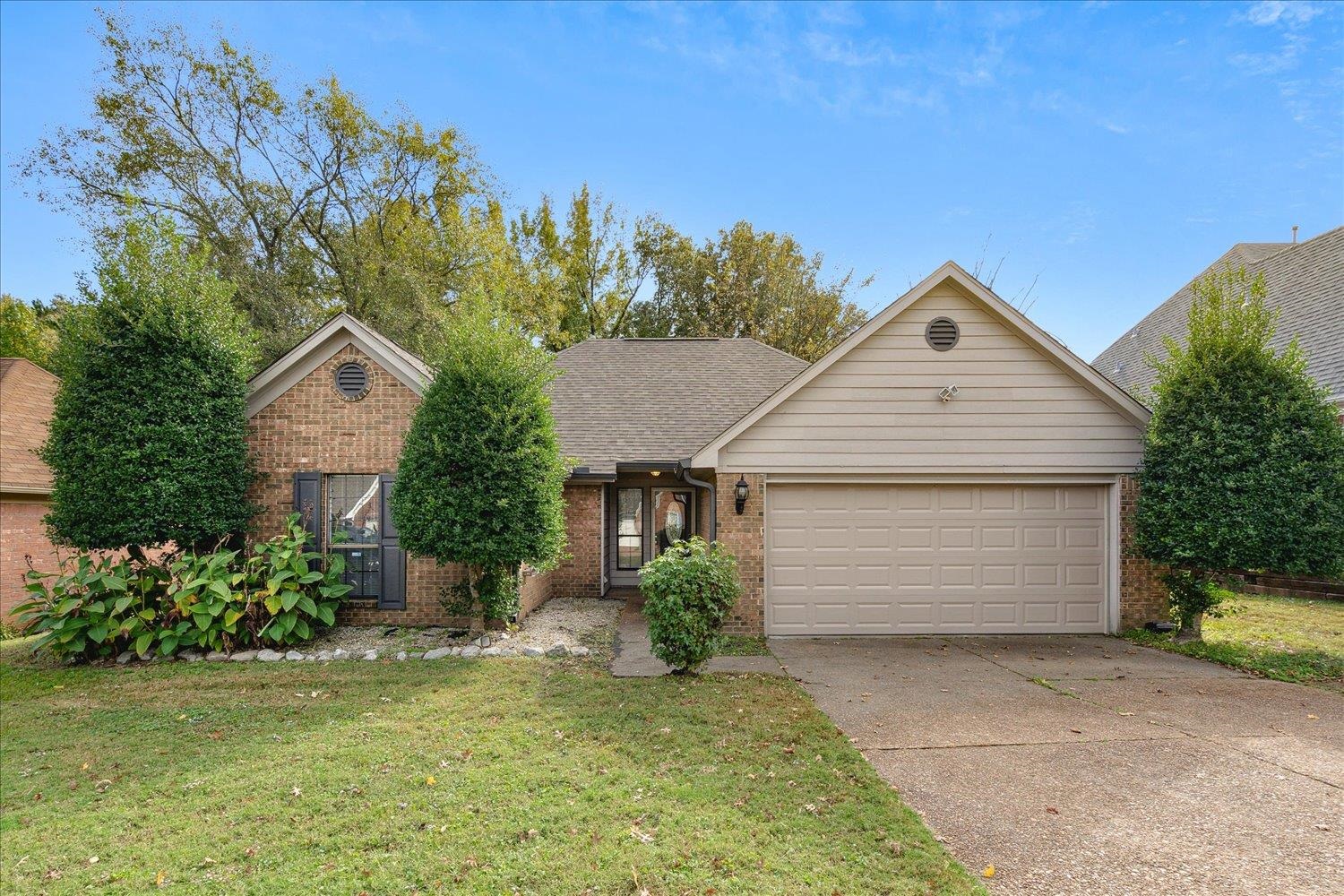 View of front of home featuring a front yard and a garage