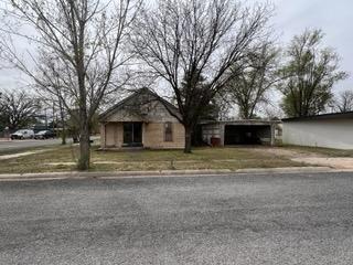 a view of a house with a yard and large trees