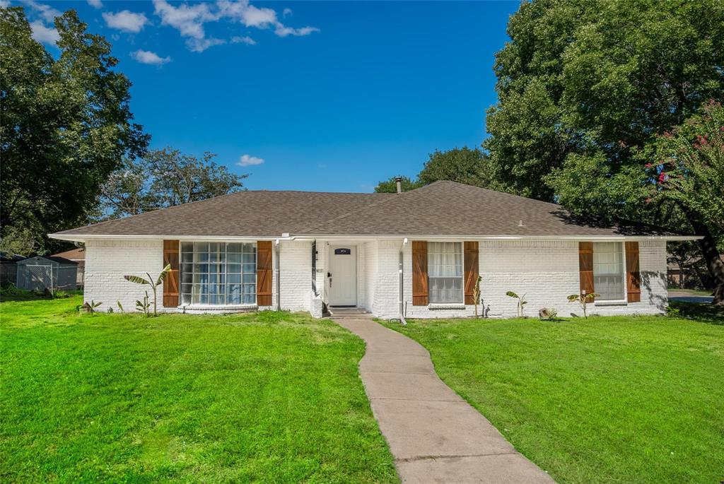 a front view of a house with a yard and trees