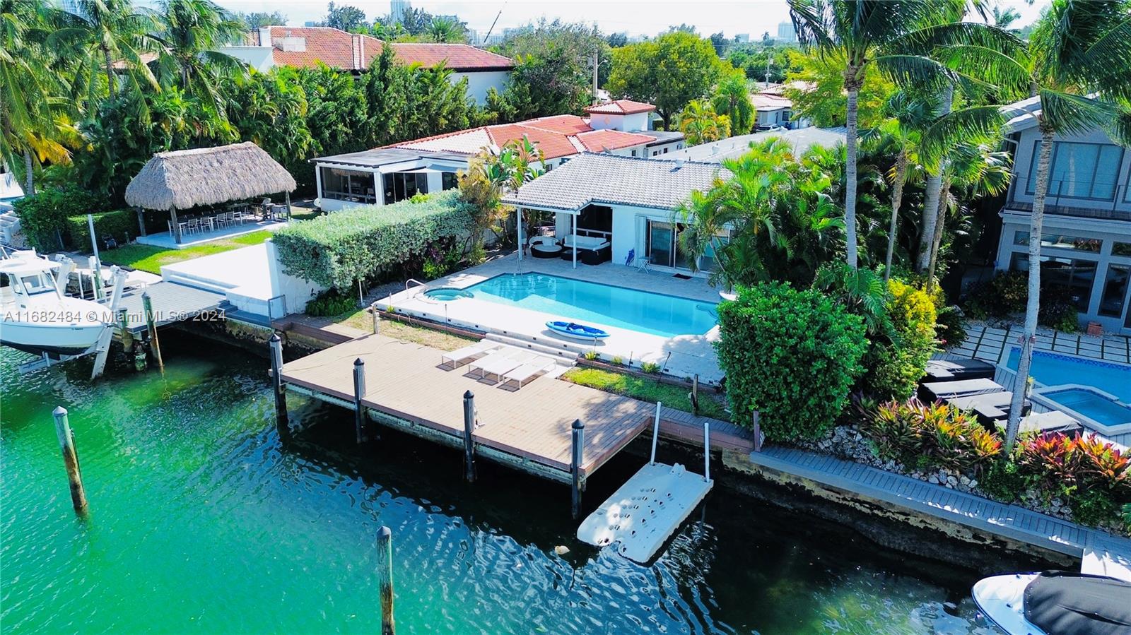 a aerial view of a house with swimming pool garden view and a chairs