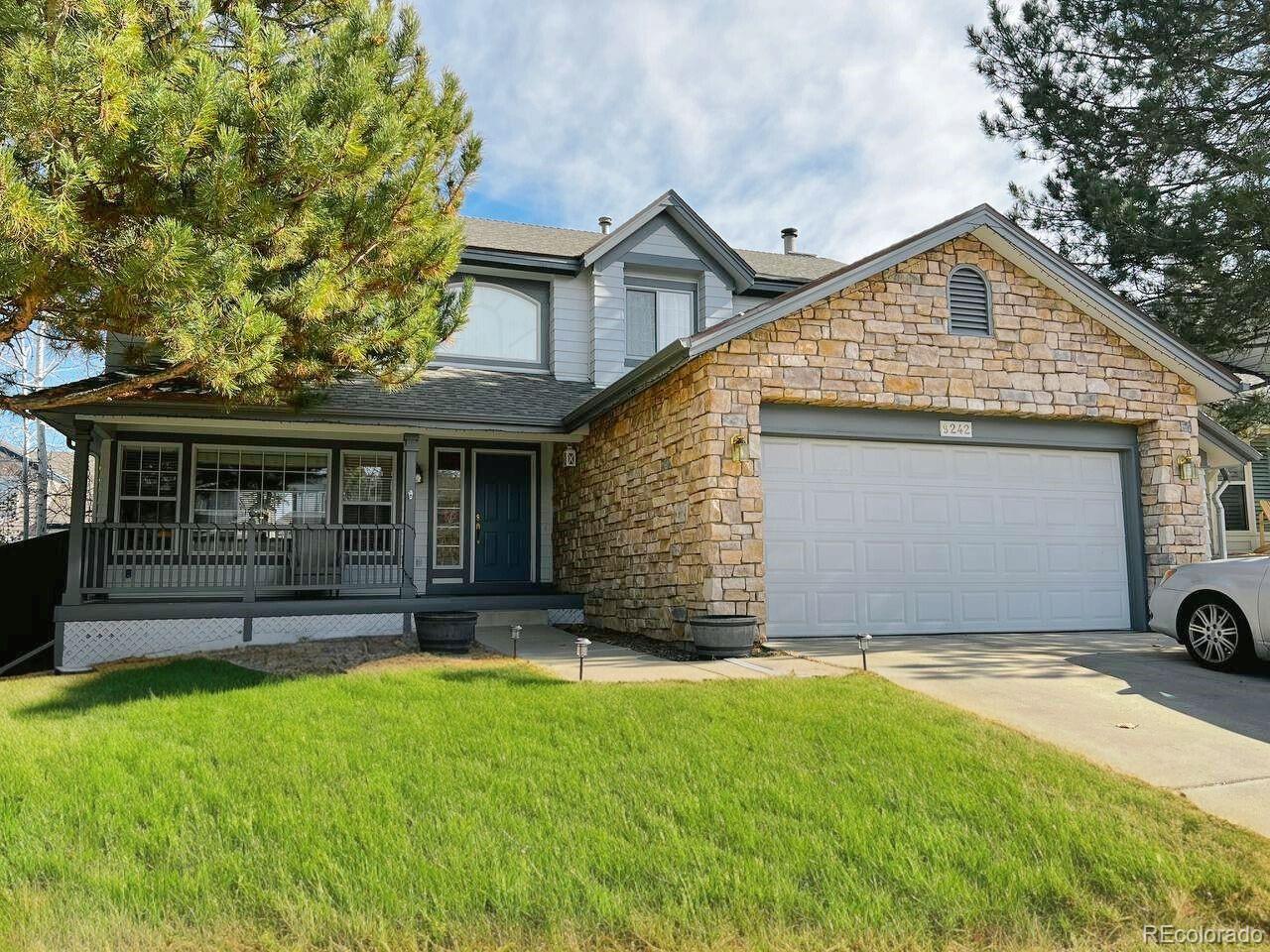 a view of a house with yard and garage