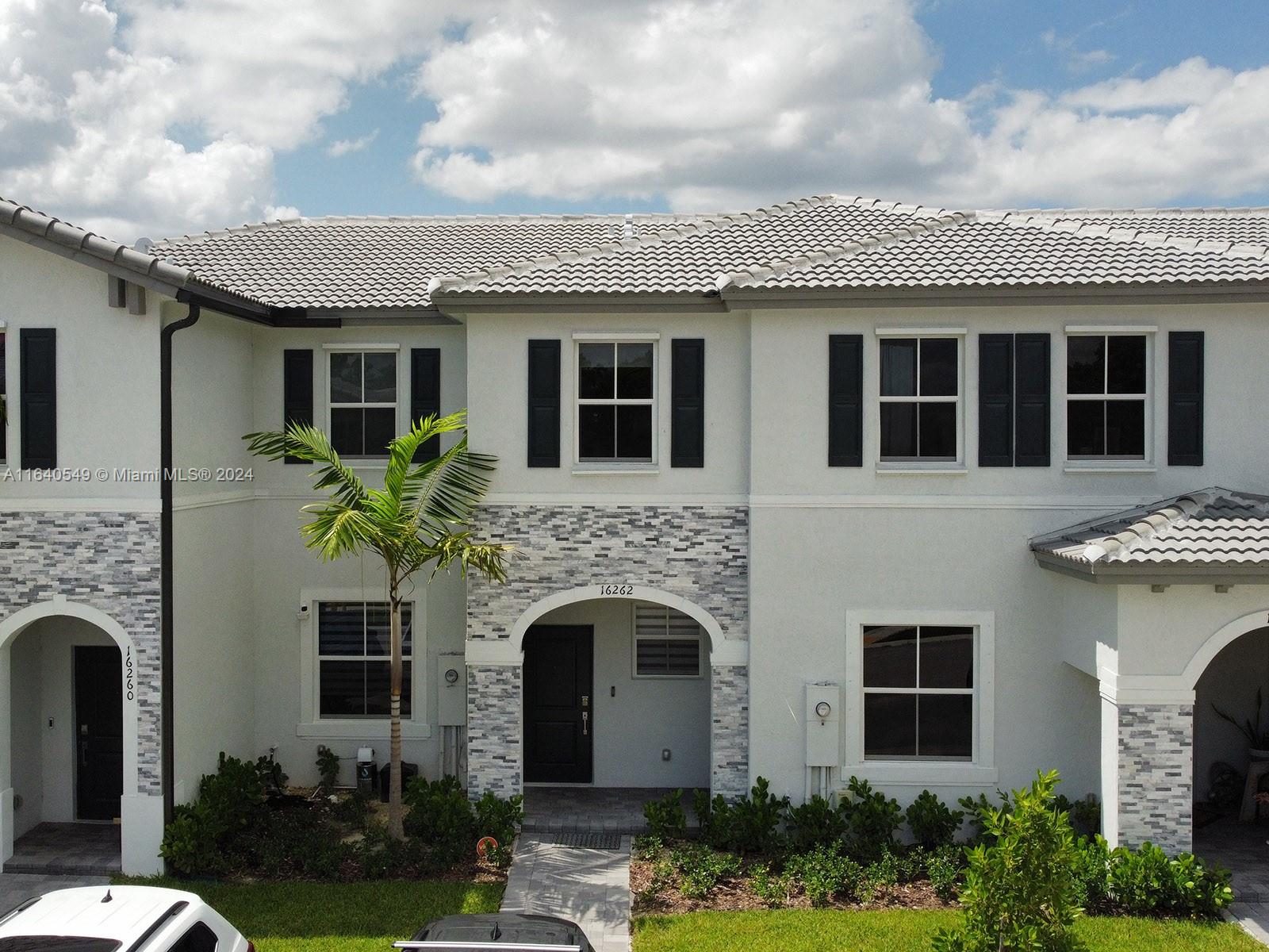 a front view of a house with plants