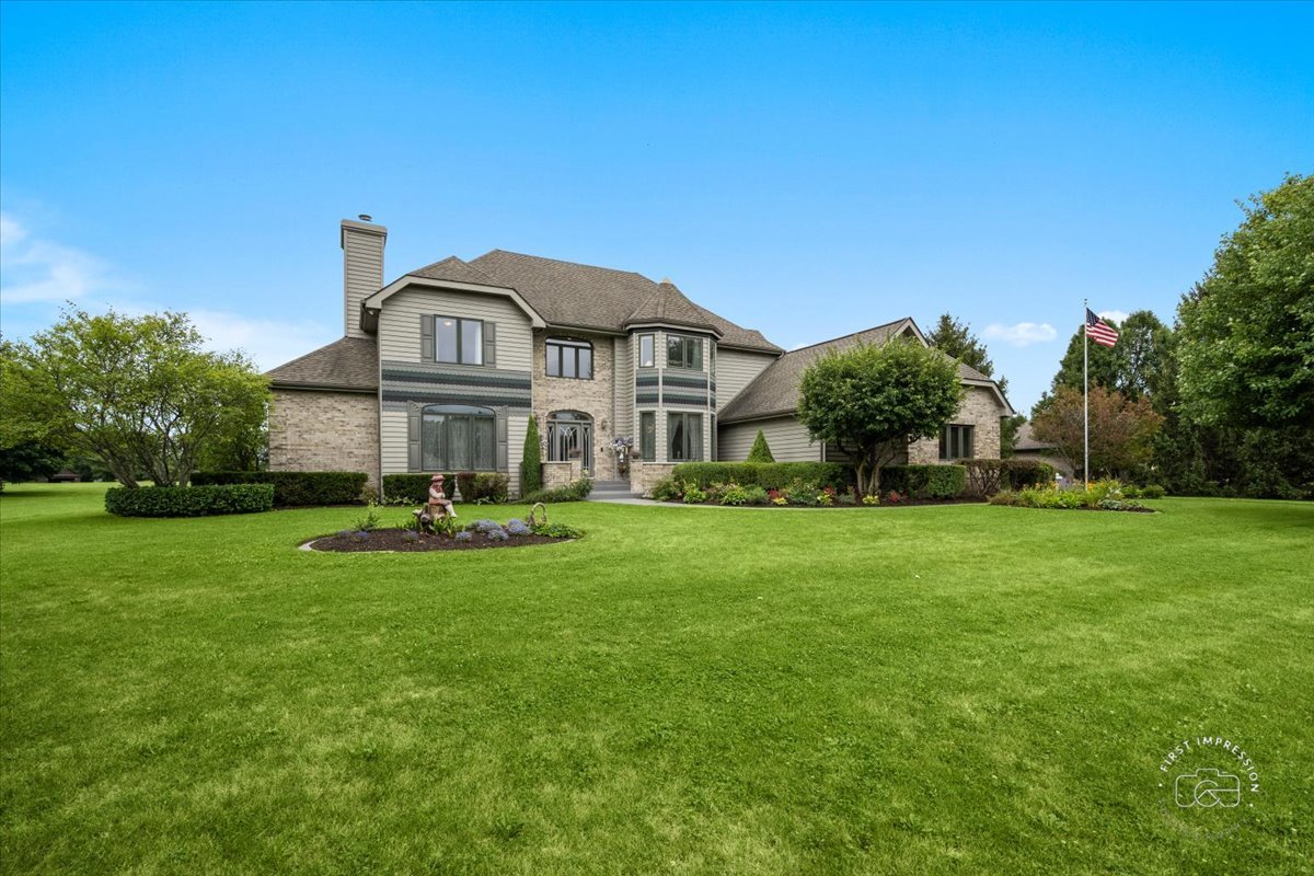 a front view of a house with garden and trees