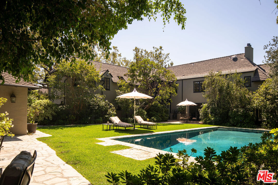 a view of a swimming pool with an outdoor seating and a yard