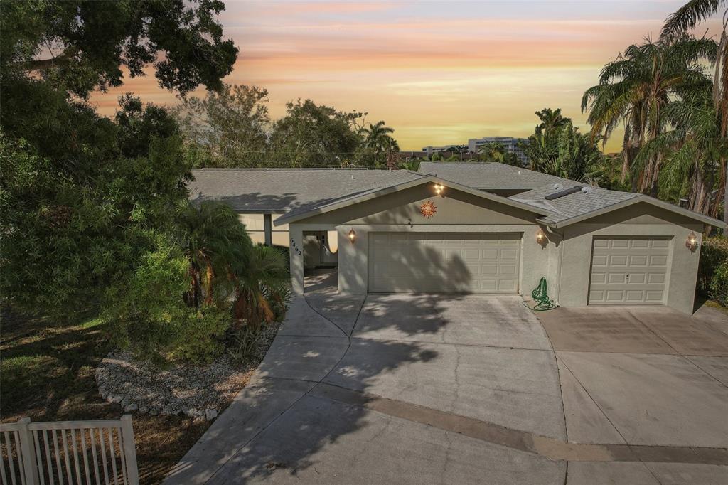 a view of a house with a yard and palm trees