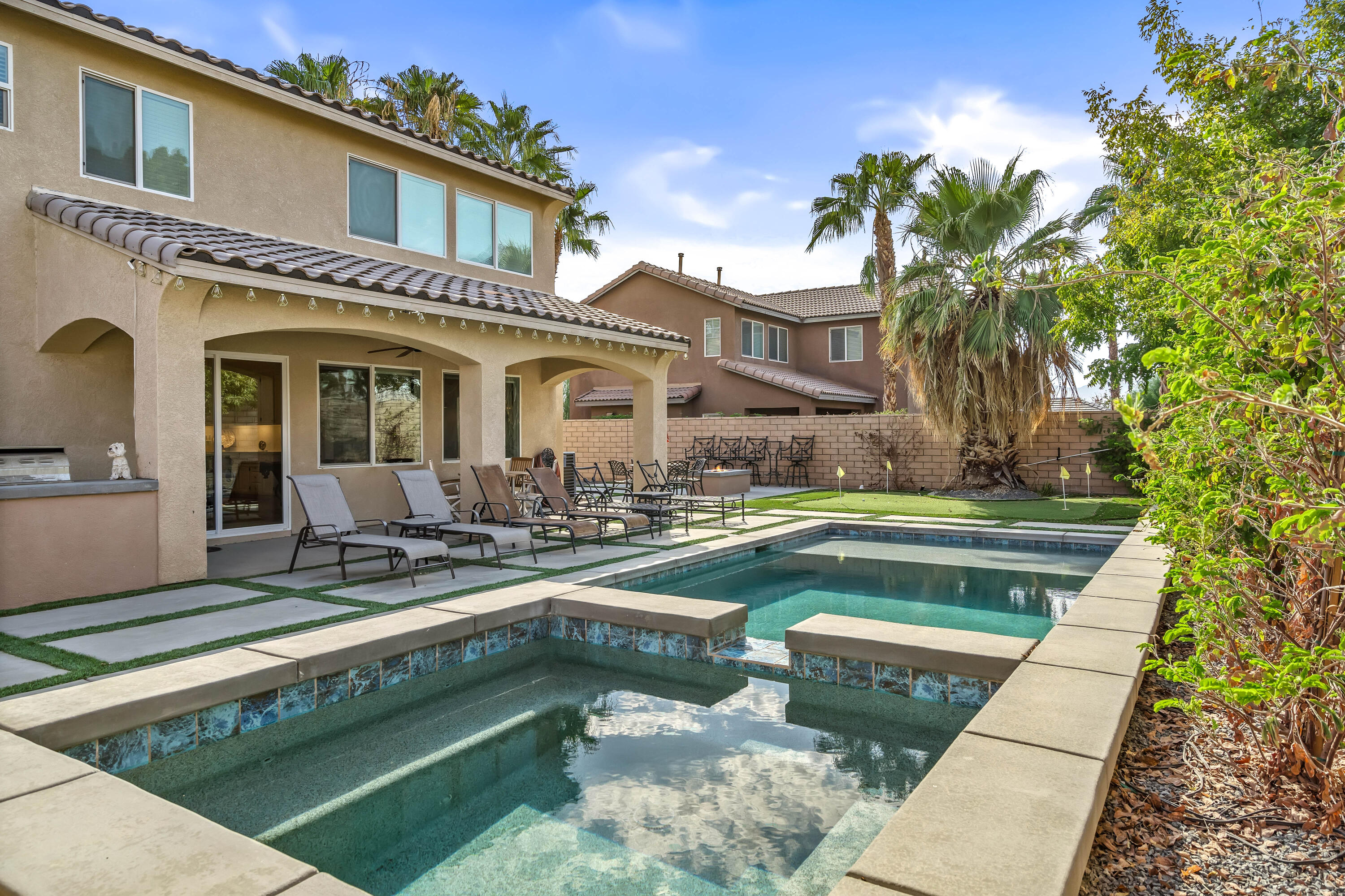 a view of a house with swimming pool and sitting area