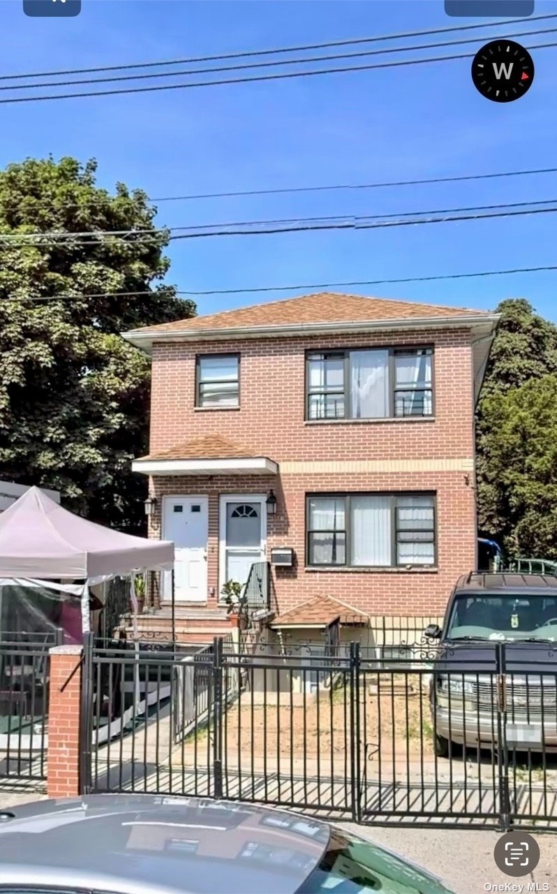 a view of a brick house with a iron gate