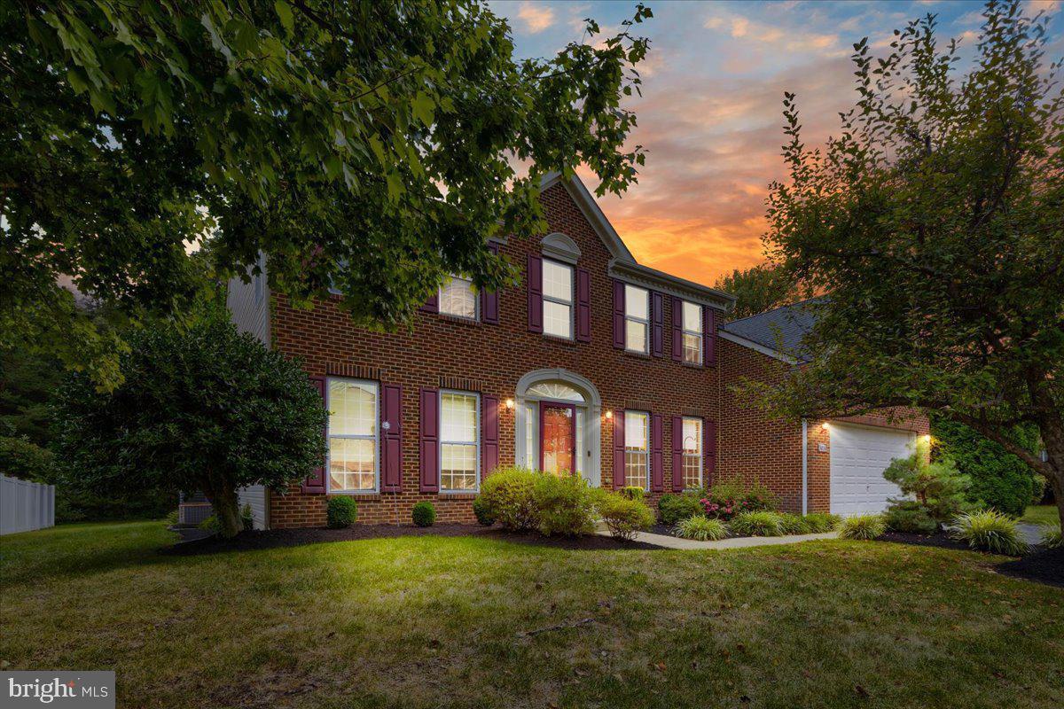 front view of a brick house with a yard