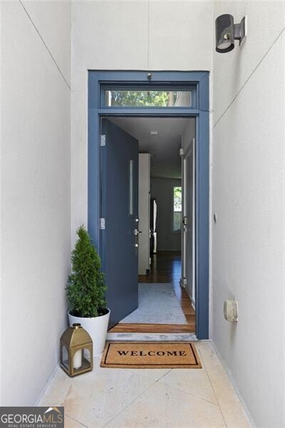 a view of a hallway with wooden floor and a potted plant