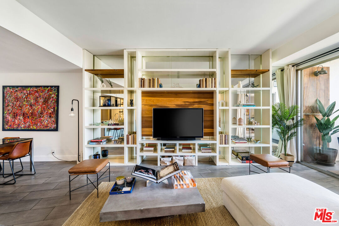 a living room with furniture a flat screen tv and next to a window