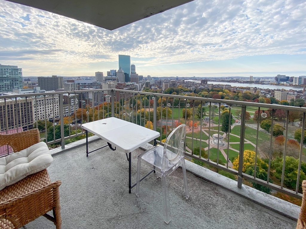 a view of a terrace with furniture and city view