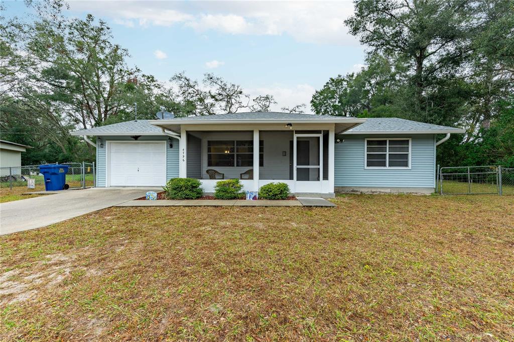 a front view of house with yard and trees around