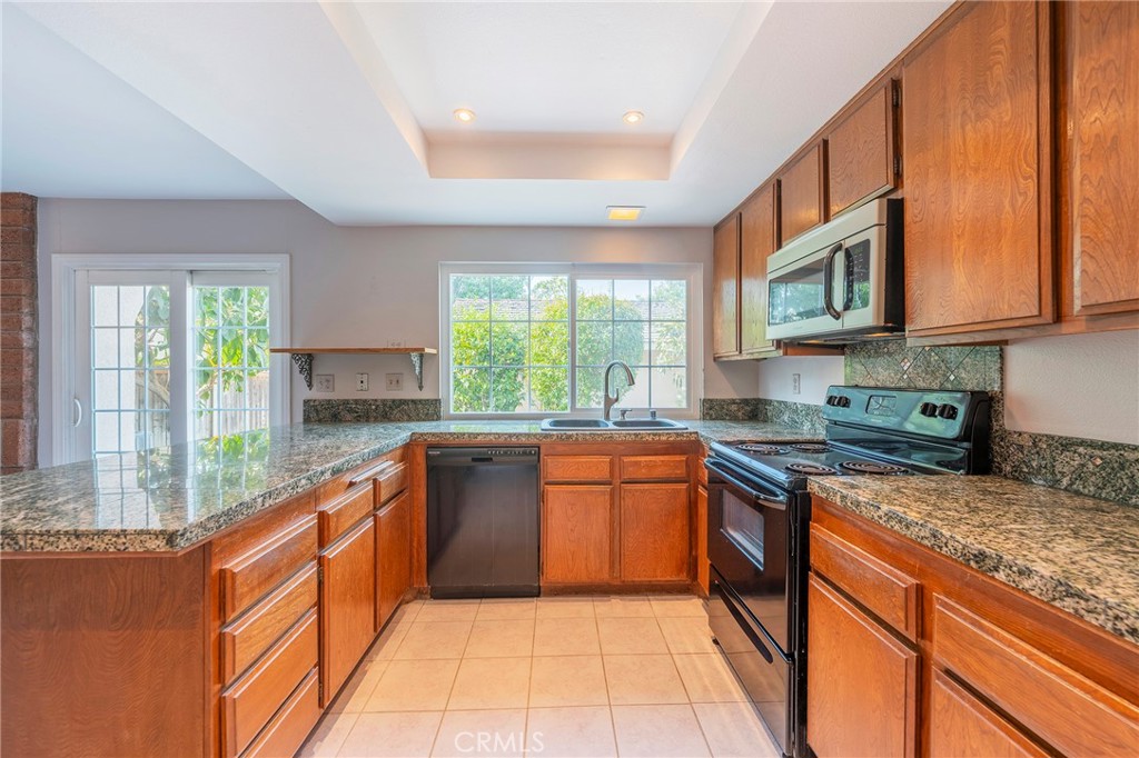 a large kitchen with stainless steel appliances granite countertop a stove a sink and a microwave