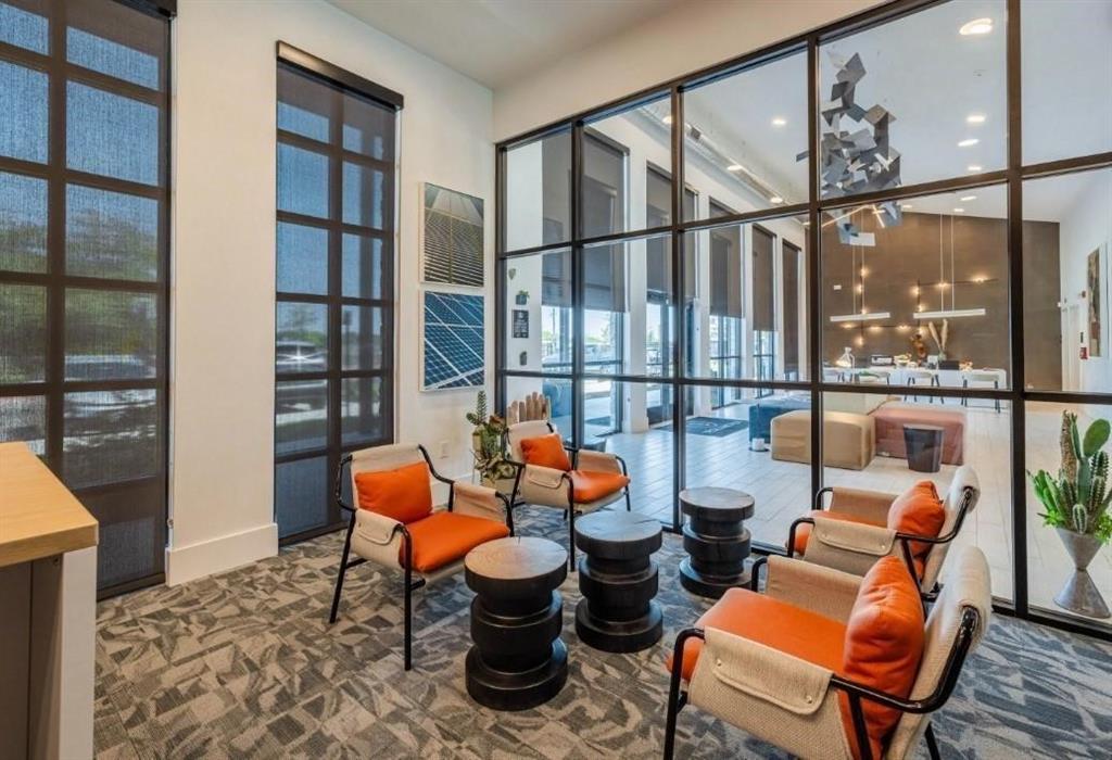 a reading room with furniture and a floor to ceiling window