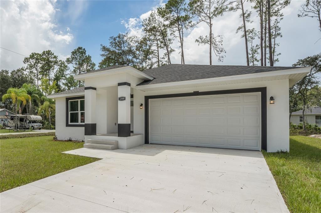 a view of a house with a yard and garage