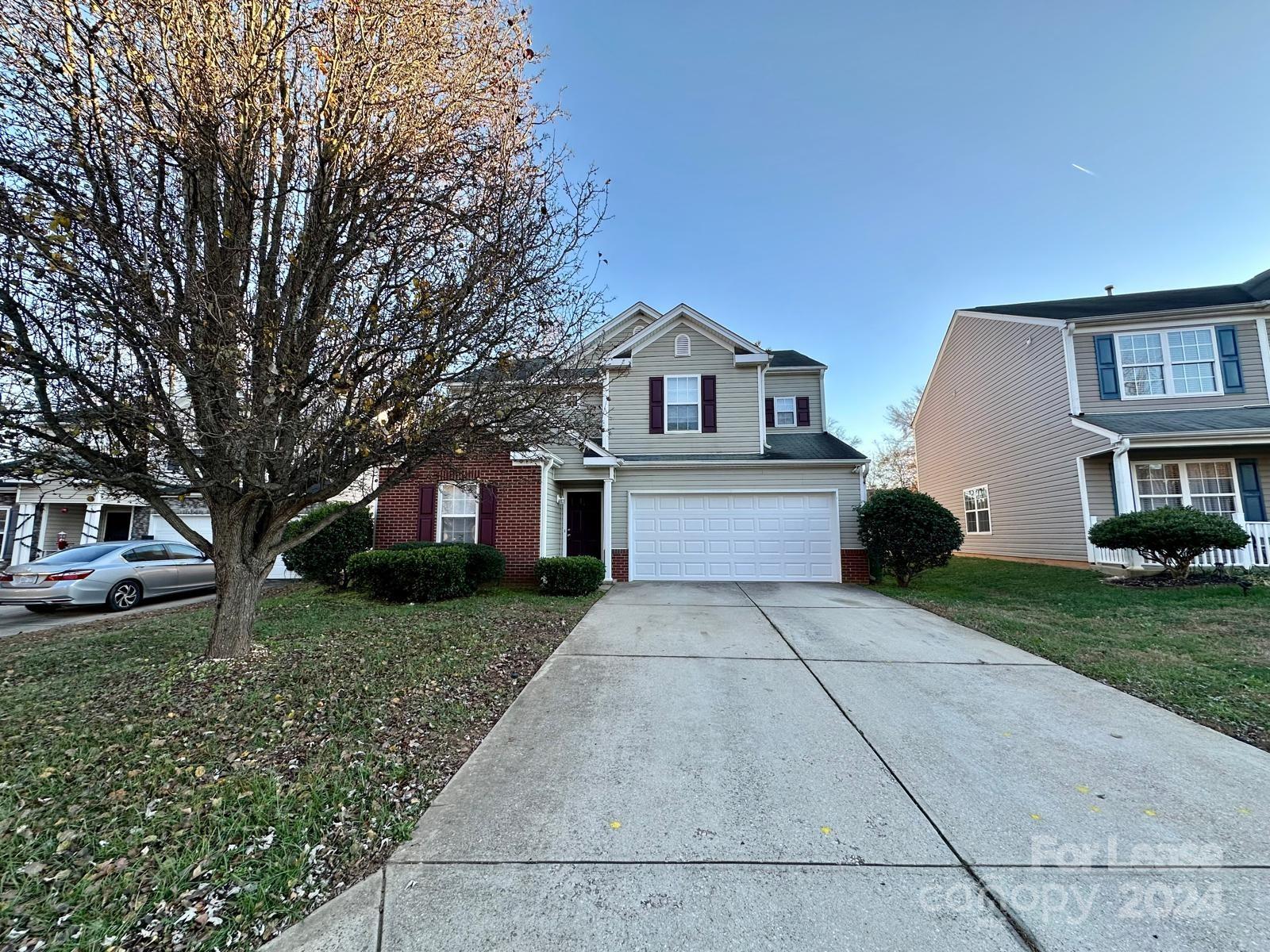 a front view of a house with a yard and trees