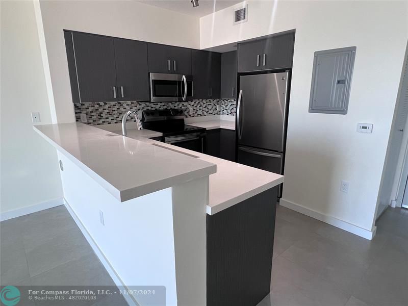 a kitchen with stainless steel appliances a refrigerator and a microwave