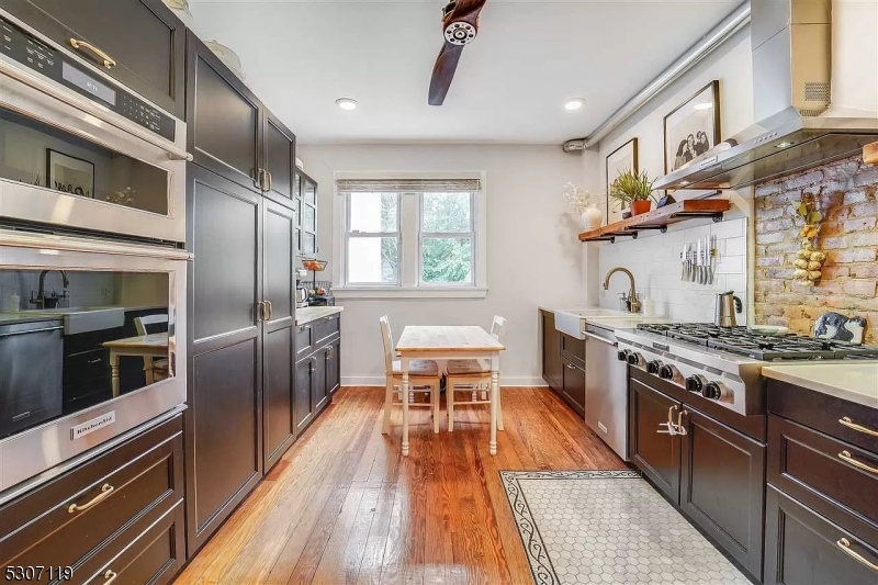 a kitchen with stainless steel appliances granite countertop a stove top oven a sink with wooden floors