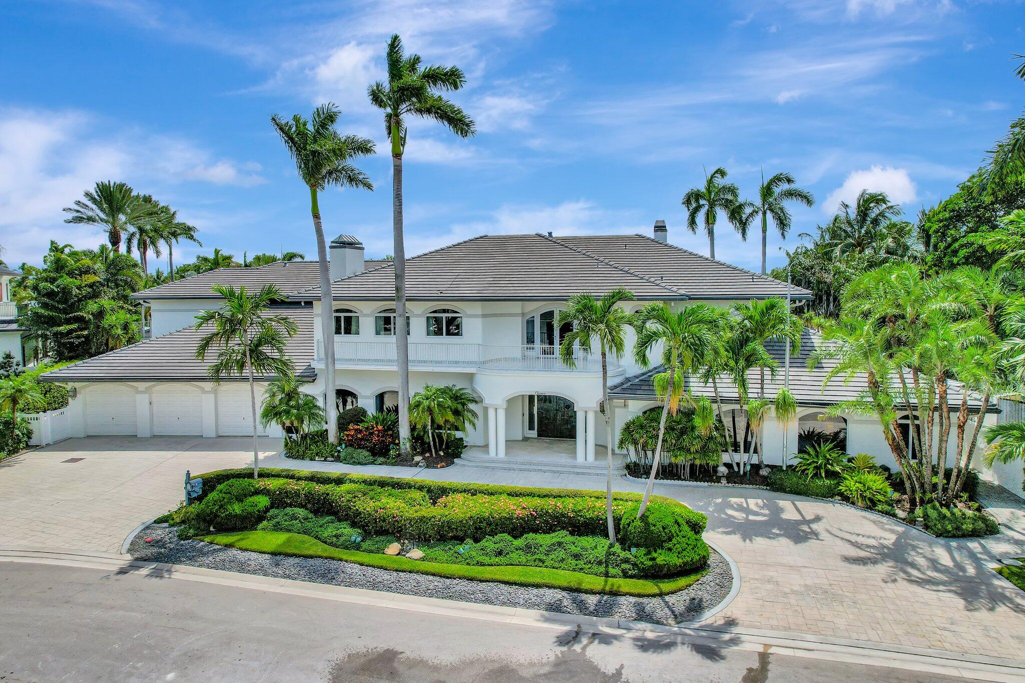 a front view of a house with a yard and potted plants