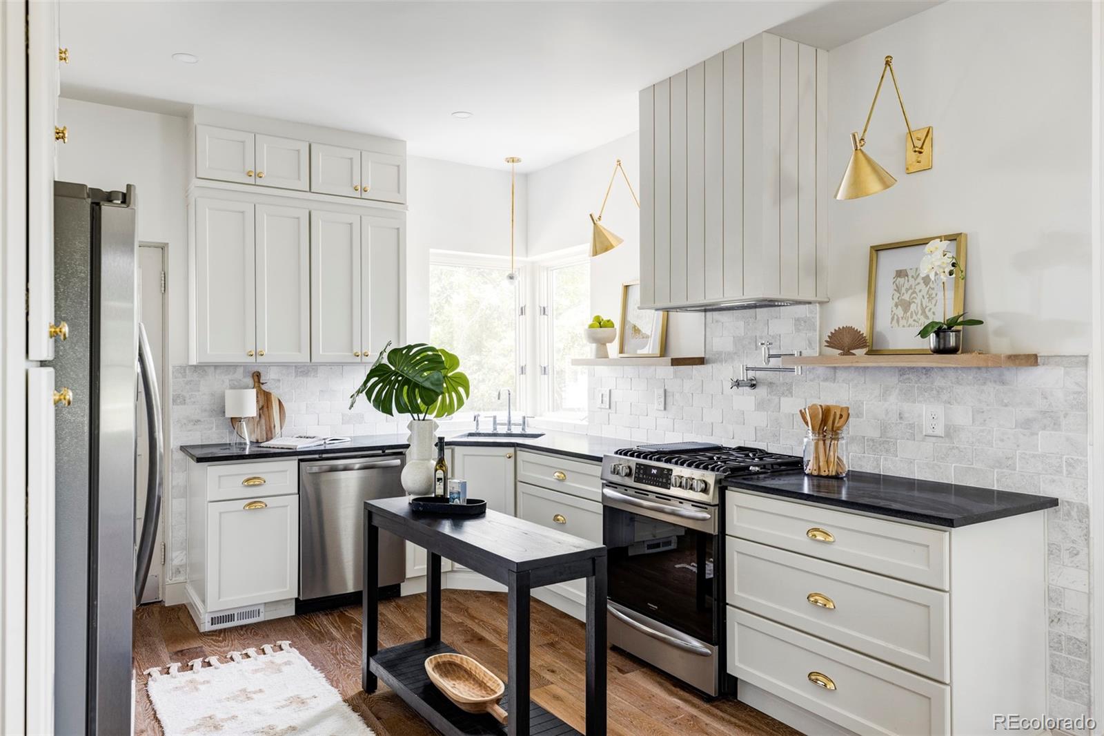 a kitchen with stainless steel appliances a sink a stove and cabinets